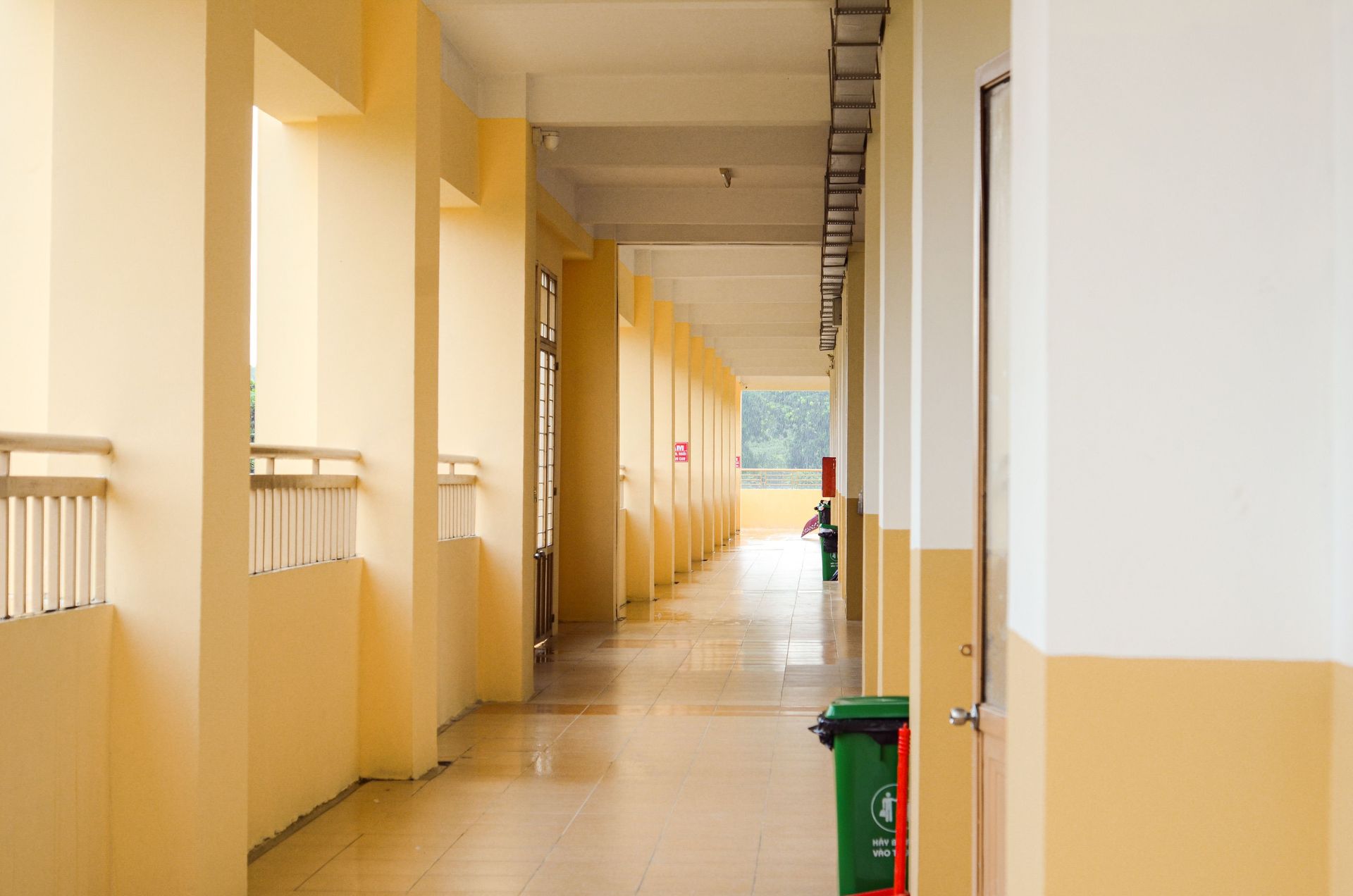 A spacious yellow corridor with trash bins, ideal for background or architectural themes.